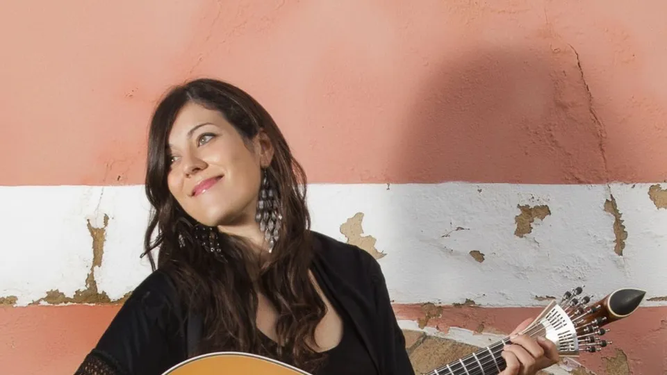 Donna portoghese seduta che suona strumento musicale a corde